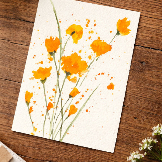 Artistic depiction of watercolor orange flowers on a white card, placed on a wooden surface.